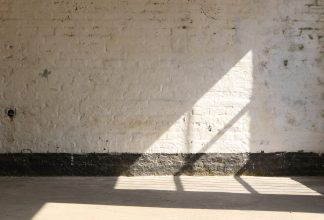 white prison wall in Montenegro w ray of sunshine